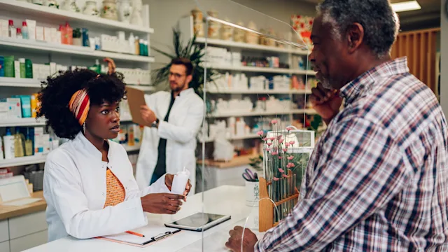 Allergies: pharmacist speaking to a customer 1765841206