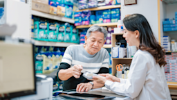 A customer speaks with a pharmacist at the pharmacy counter.
Edwin Tan/E+ via Getty Images