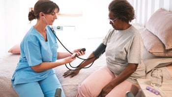 Hypertension: African American:  caregiver checking blood pressure 1423887867