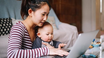 low cost free healthcare: SNAP benefits: mom using laptop with baby 1077259686