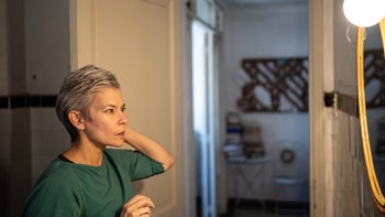 Health: Menopause: woman looking at the mirror at home 1405269410