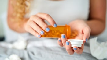 vertigo: closeup pouring medication from pill bottle 1150940271