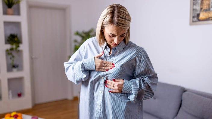 A person examining lumps in their breast.