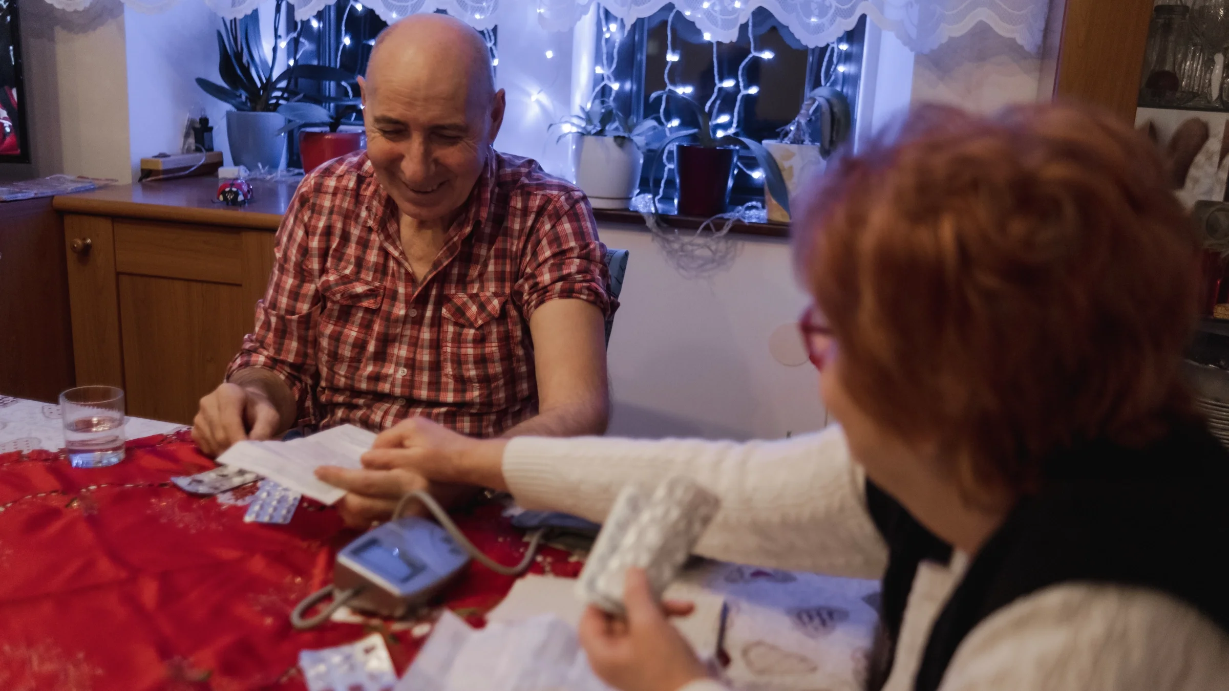 A couple measuring blood pressure and readingg pill inserts.