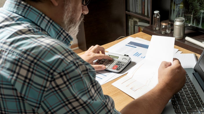 A man is reviewing financial paperwork in a close-up.