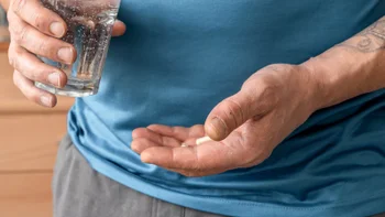 Medication Education: closeup man taking medication with water 2279787694