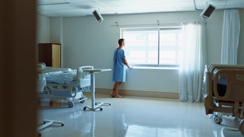 Health: Birth control: man hospital gown at window-493216327