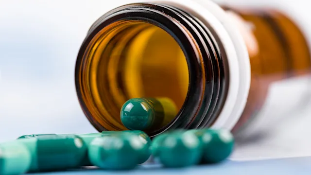 Keflex: green capsules spilling out of bottle 637075536