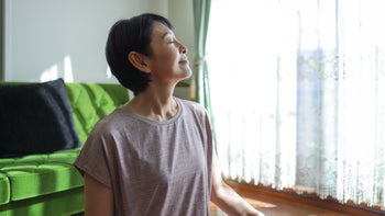 Alternative treatments: woman feeling the sun shine on her face 1752179225
