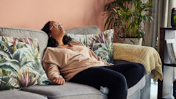 A woman is slumped on the sofa at home.
LumiNola/E+ via Getty Images
