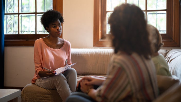 A therapist talking to a family and taking notes. 