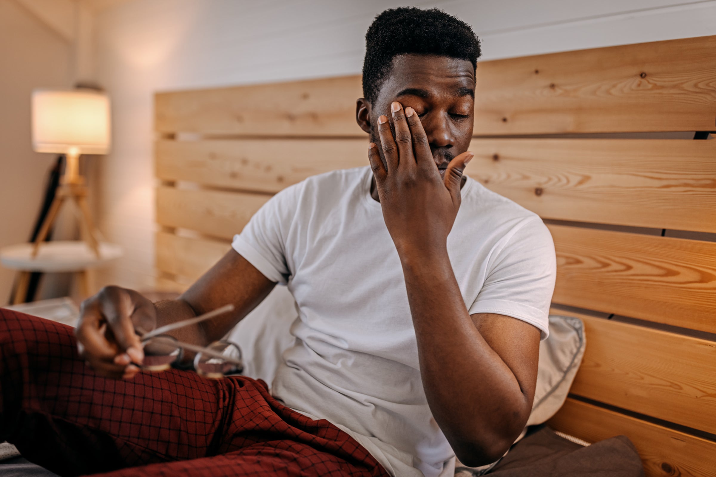 Why do we get eye boogers 1 Man waking up in the morning and rubbing his eyes before he puts on his glasses.