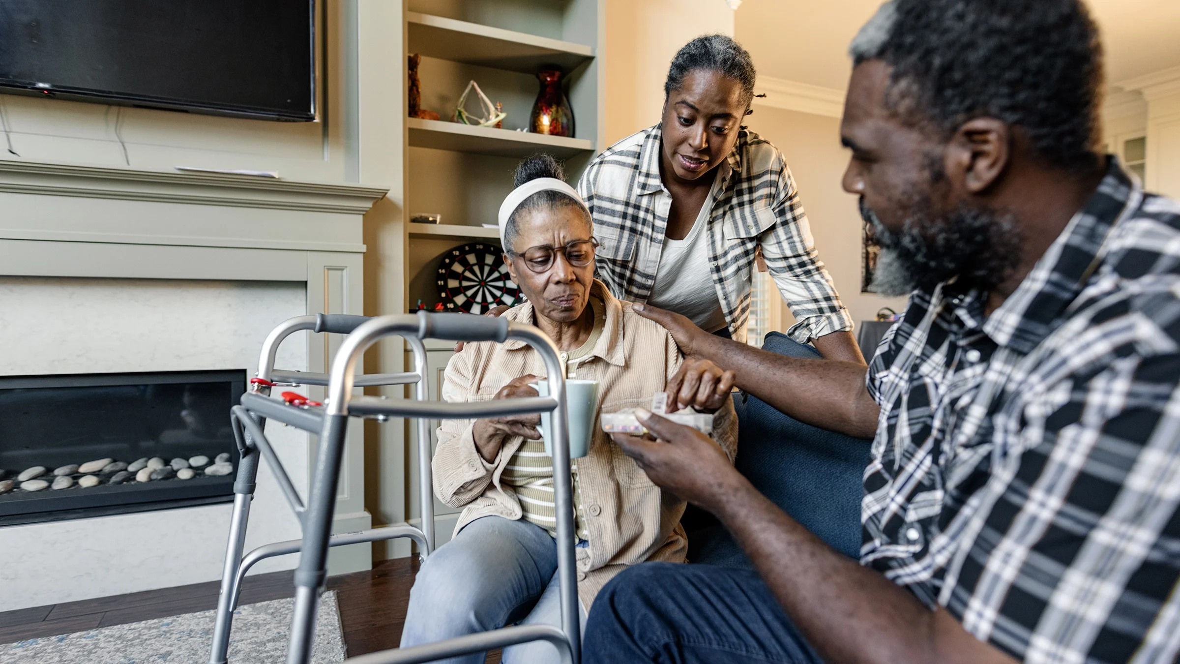 Two adults are shown caring care for an aging parent.