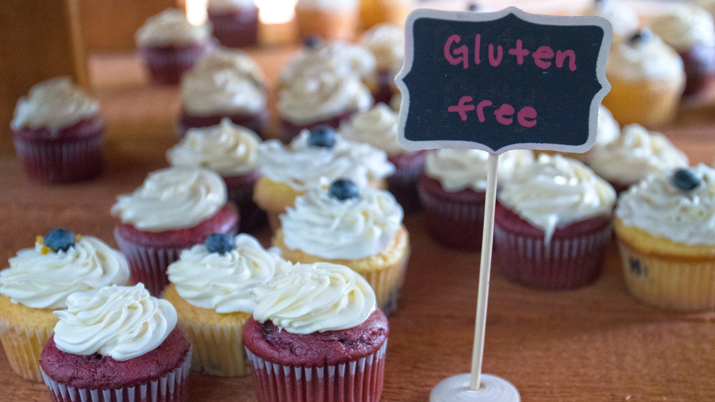 Gluten free cupcakes on display with a tiny chalkboard sign.