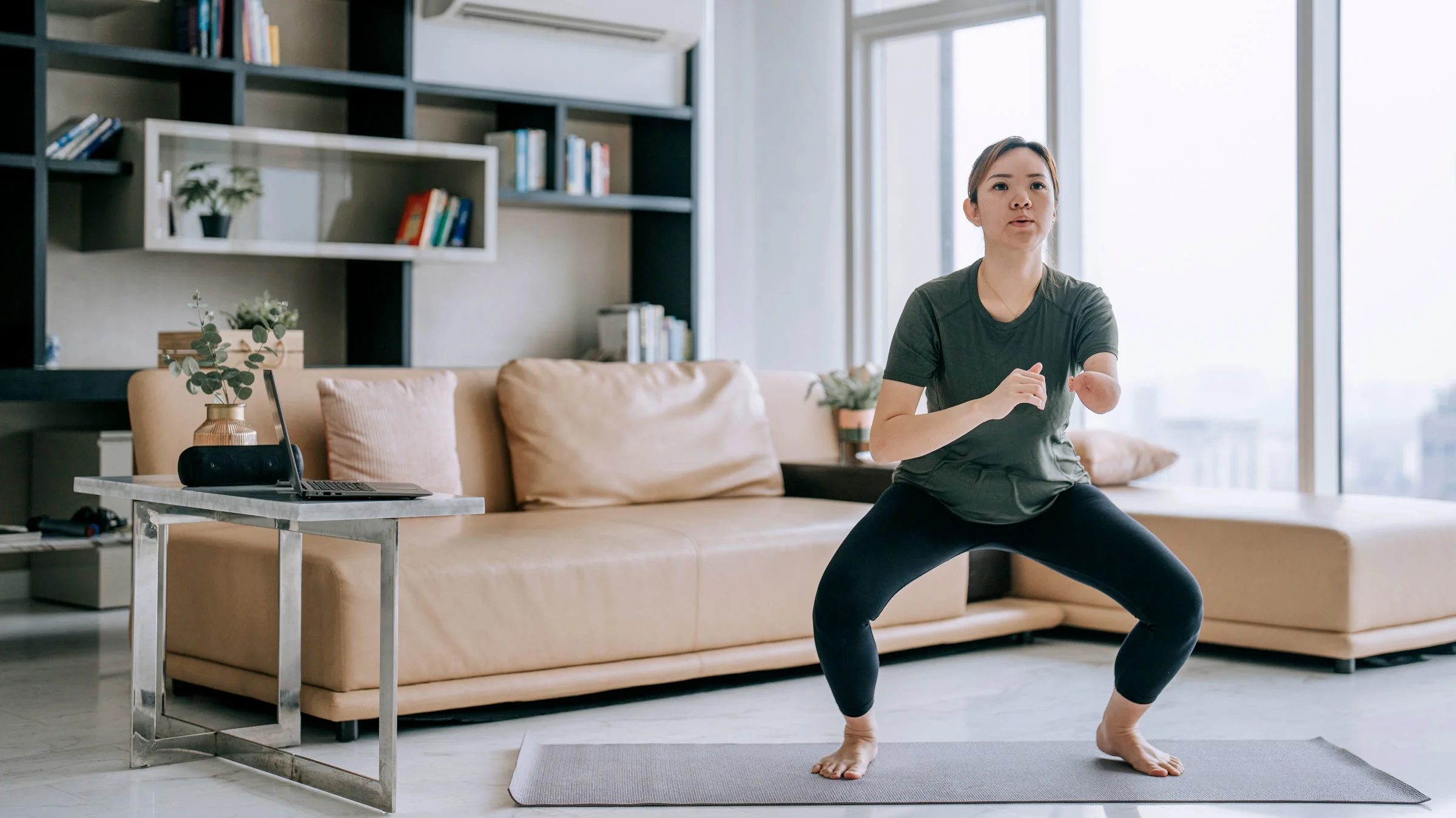 A woman is doing squat exercises at home.