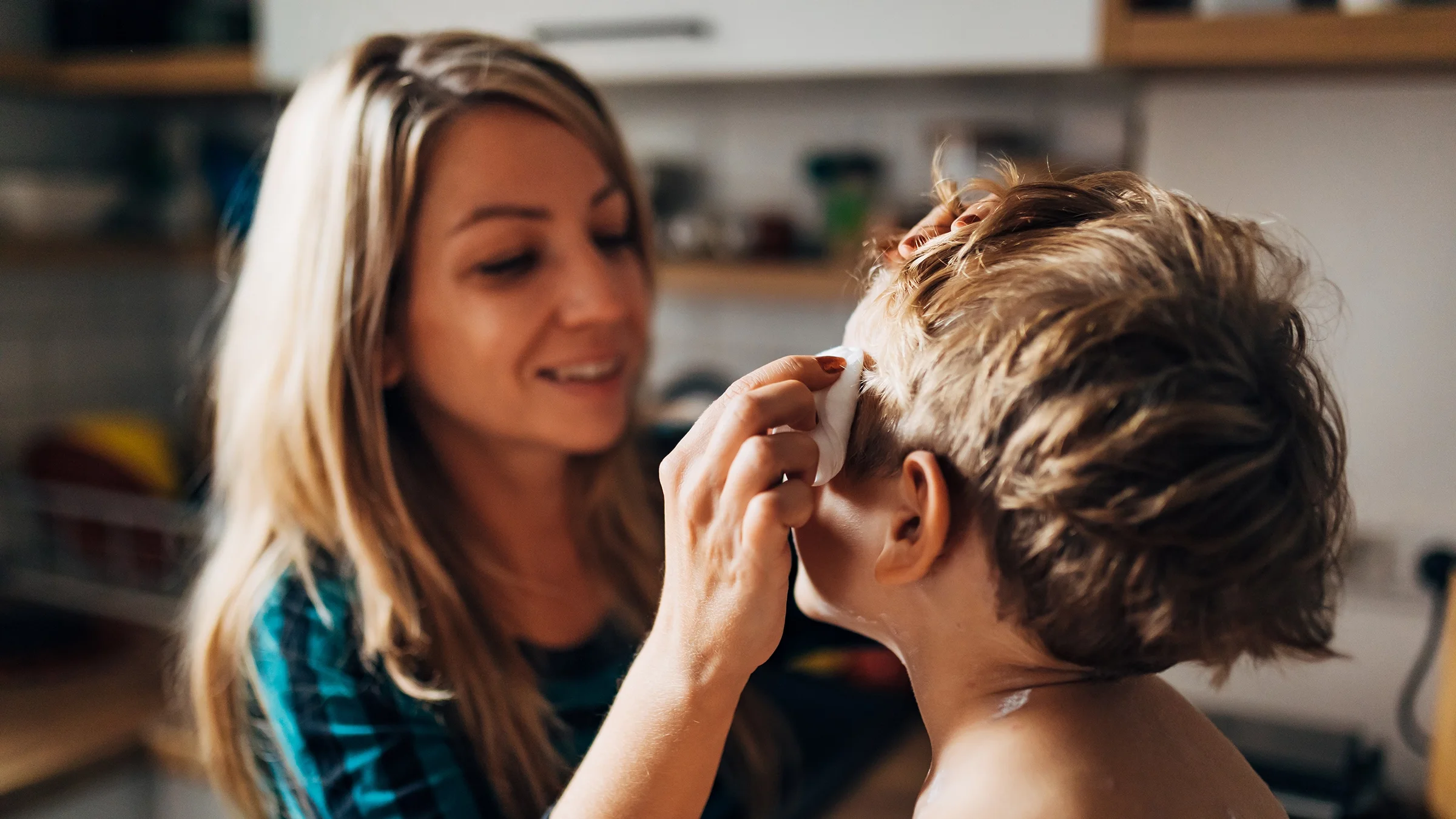 A person applies ointment to a child’s face
