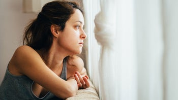 Long COVID: looking out window stressed 1214753780