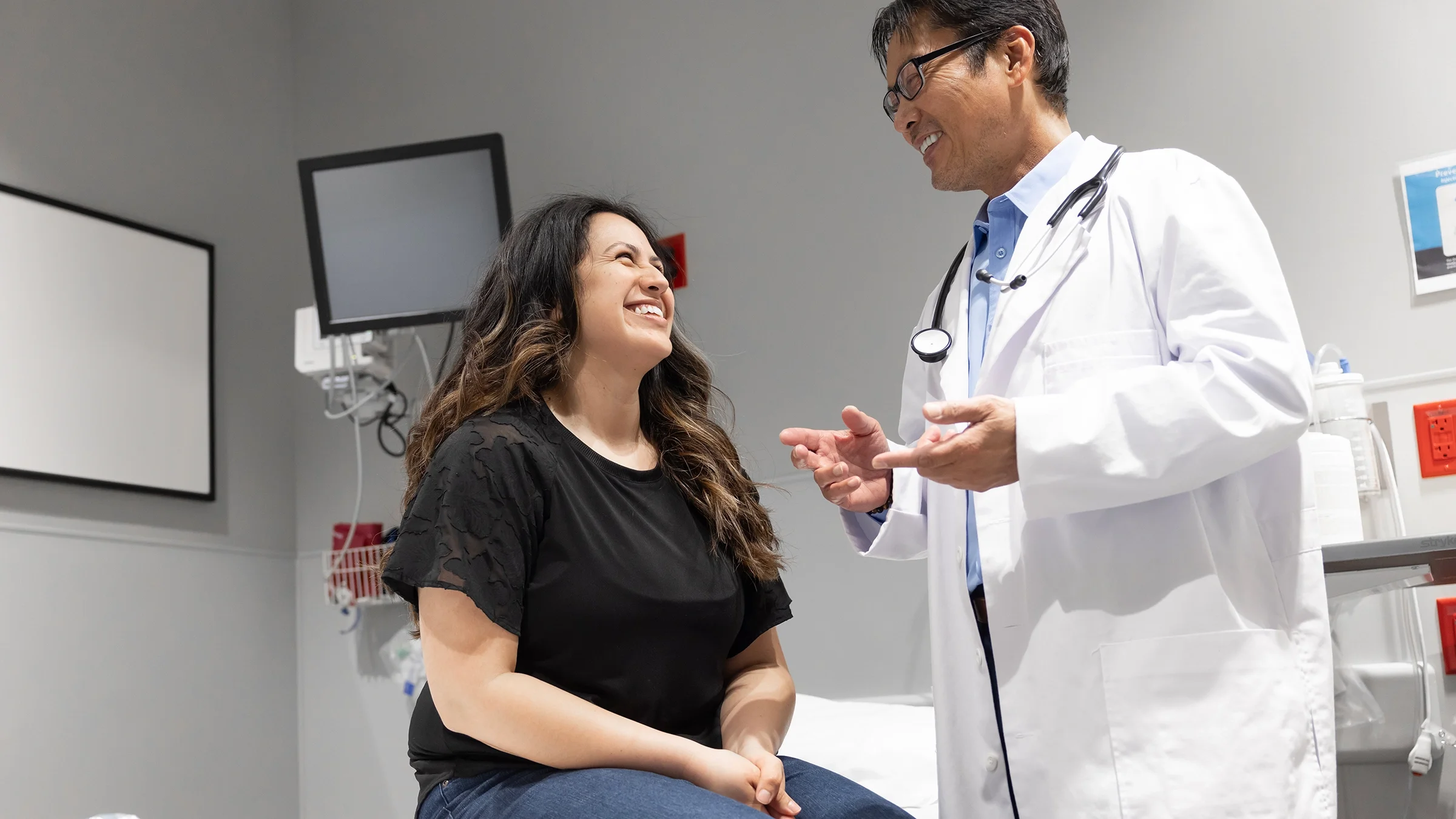 A woman talks with her healthcare professional at a medical appointment.