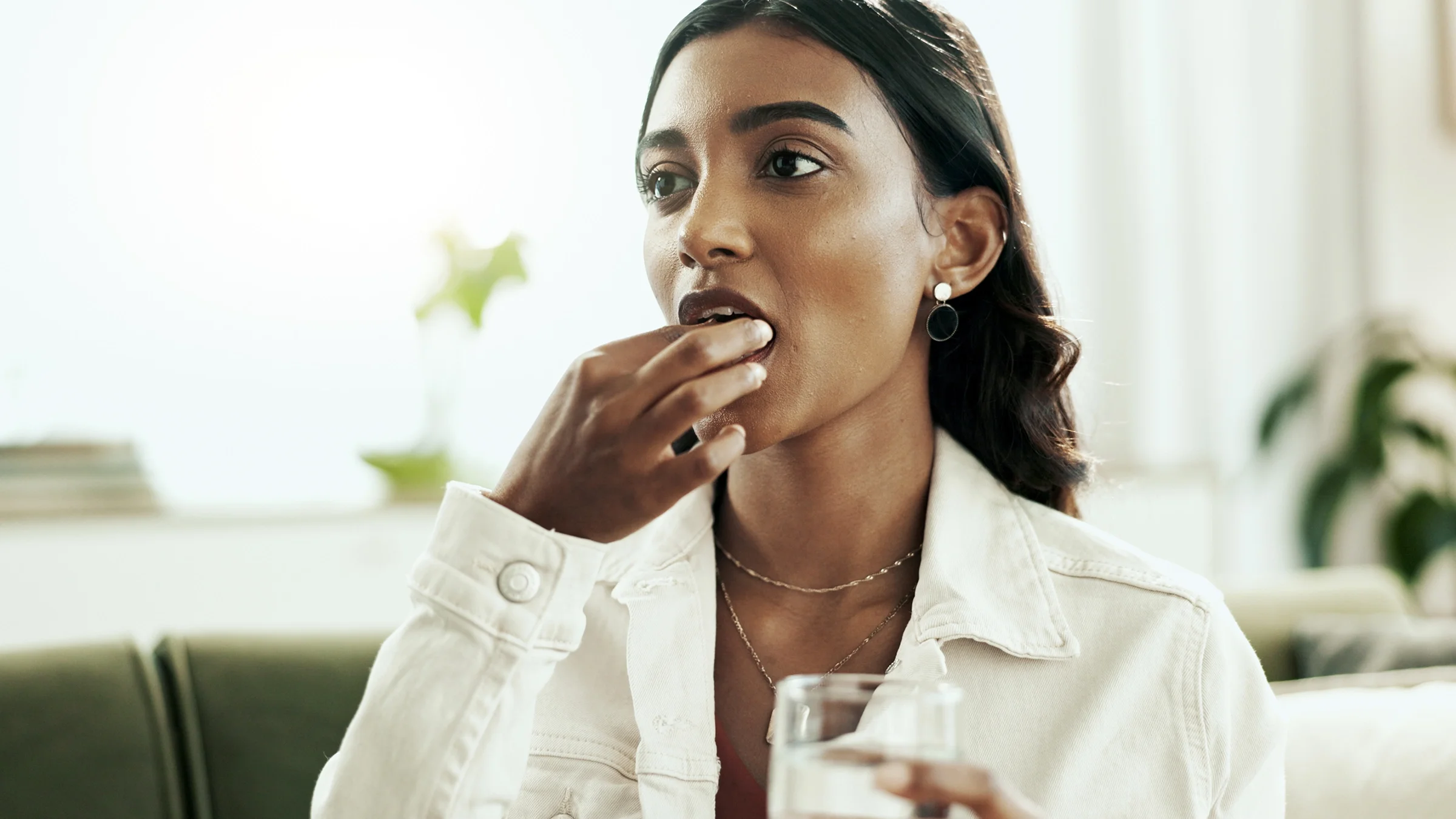A woman takes an oral pill.