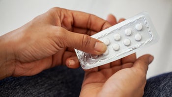 Clomid: closeup hands retrieving pills from a blister pack 1490530108