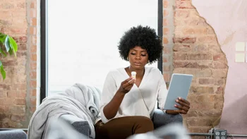 woman_reviewing_medication_holding_tablet_device-1354924014.webp