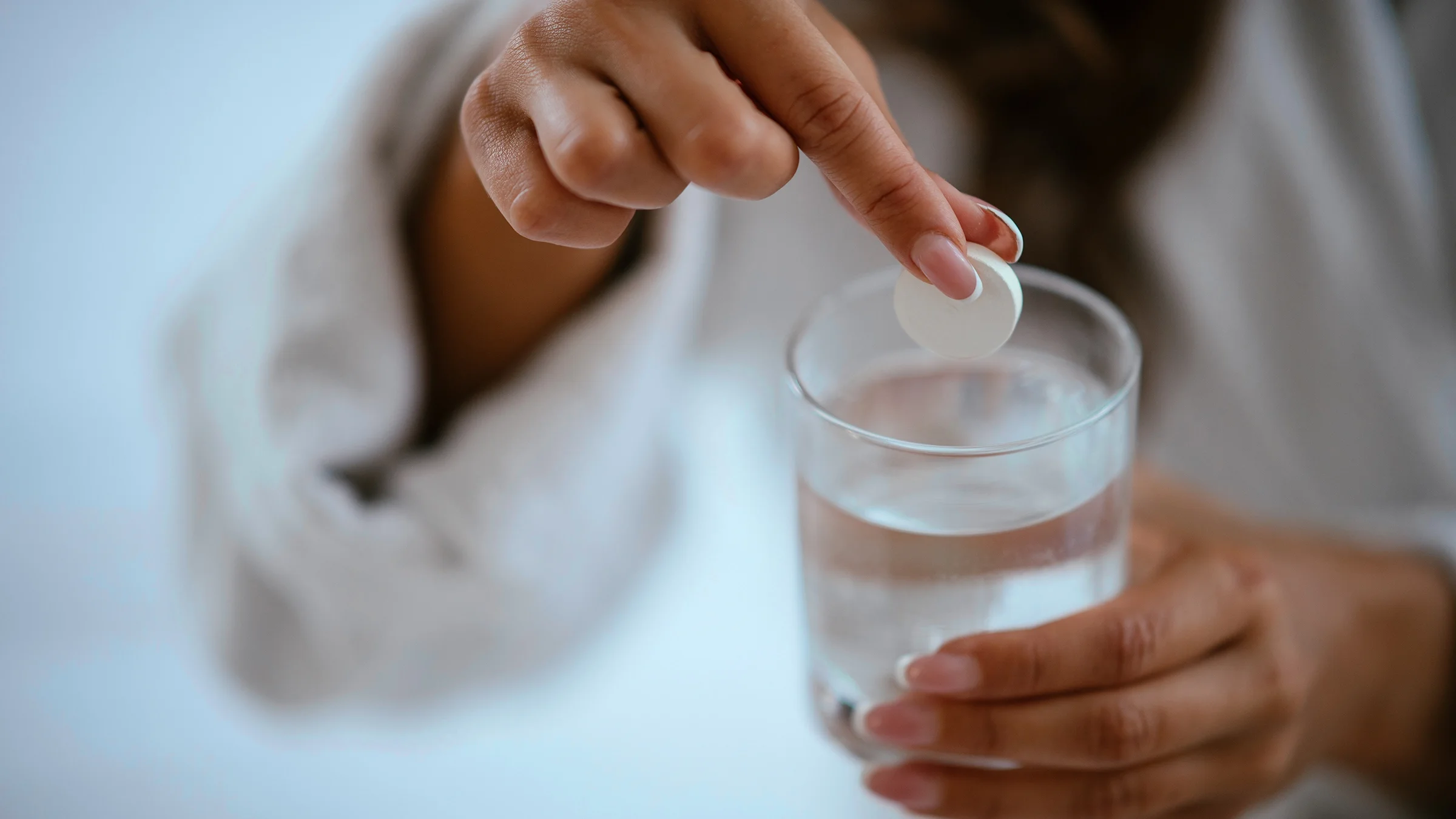 A woman dissolves antacid in water, which is one of the ways to get relief from an acid reflux attack.