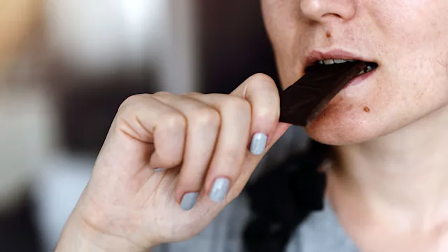 Nausea: woman eating dark chocolate 1058508020