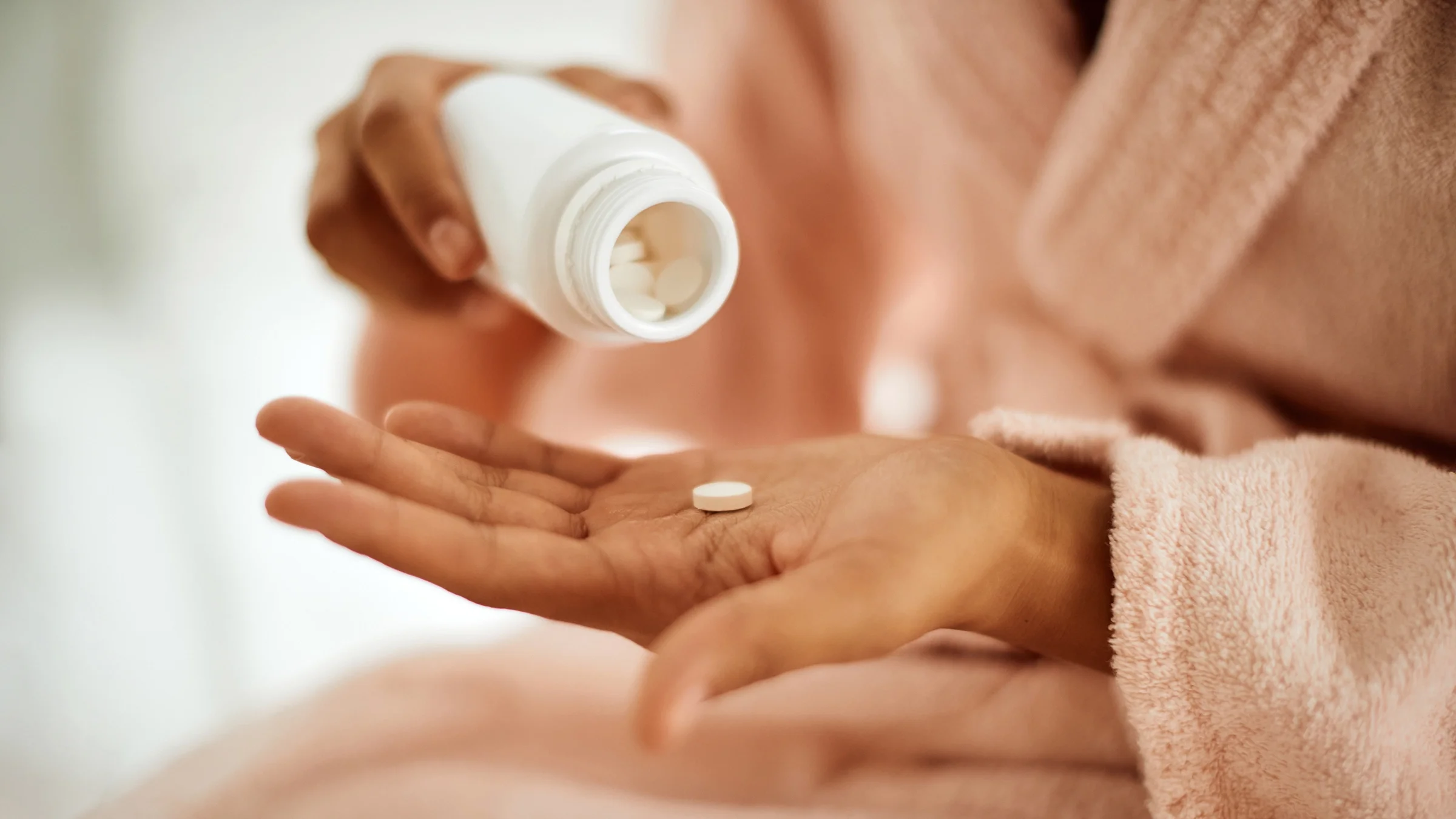 A person is taking medication at home in a close-up.