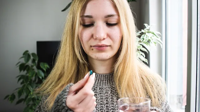 Medication education: Off-label: holding pill and glass 1382397565