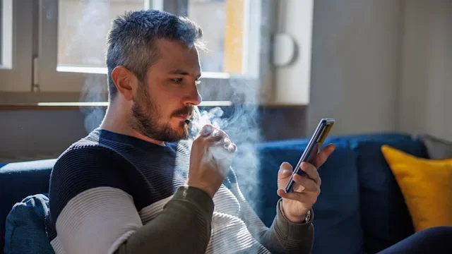 Smoking cessation: man smoking electronic cigarette 1418983675