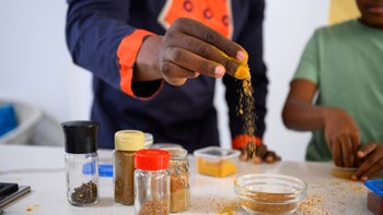 diet-nutrition: closeup hand adding spice while cooking 1690263684