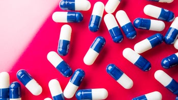 proton pump inhibitor: blue white pill red background 1436273613