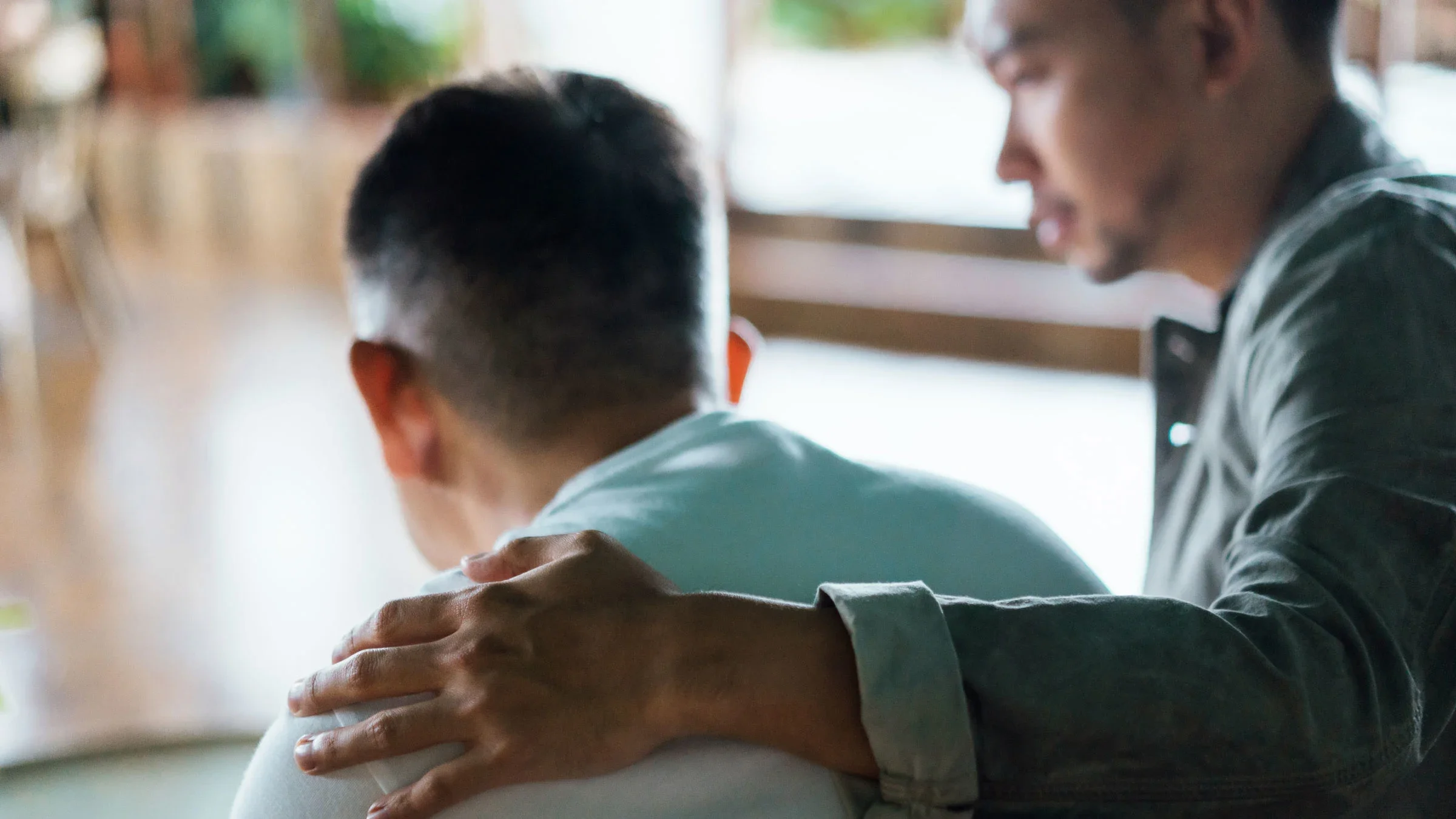 A son is putting his arm around his father.
AsiaVision/E+ via Getty Images