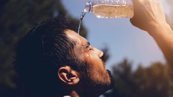 environmental: heat: hot: water: after run man pouring water over face-1173909995