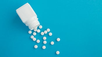 white pills white bottle blue background-1326477993