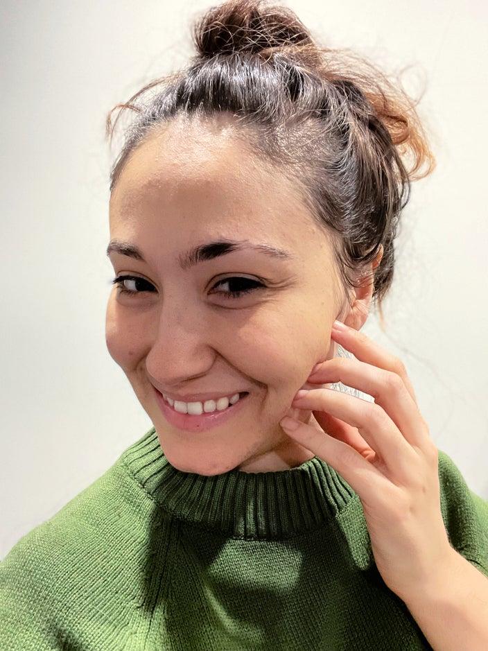 Selfie of Sarah Ribeiro with her dark hair pulled up in a messy top knot.