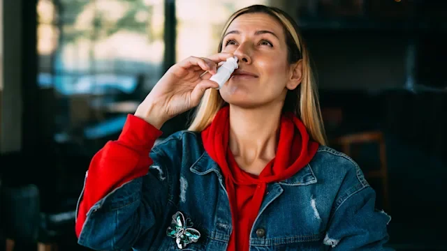 Nicotrol: woman using nasal spray 1185089905