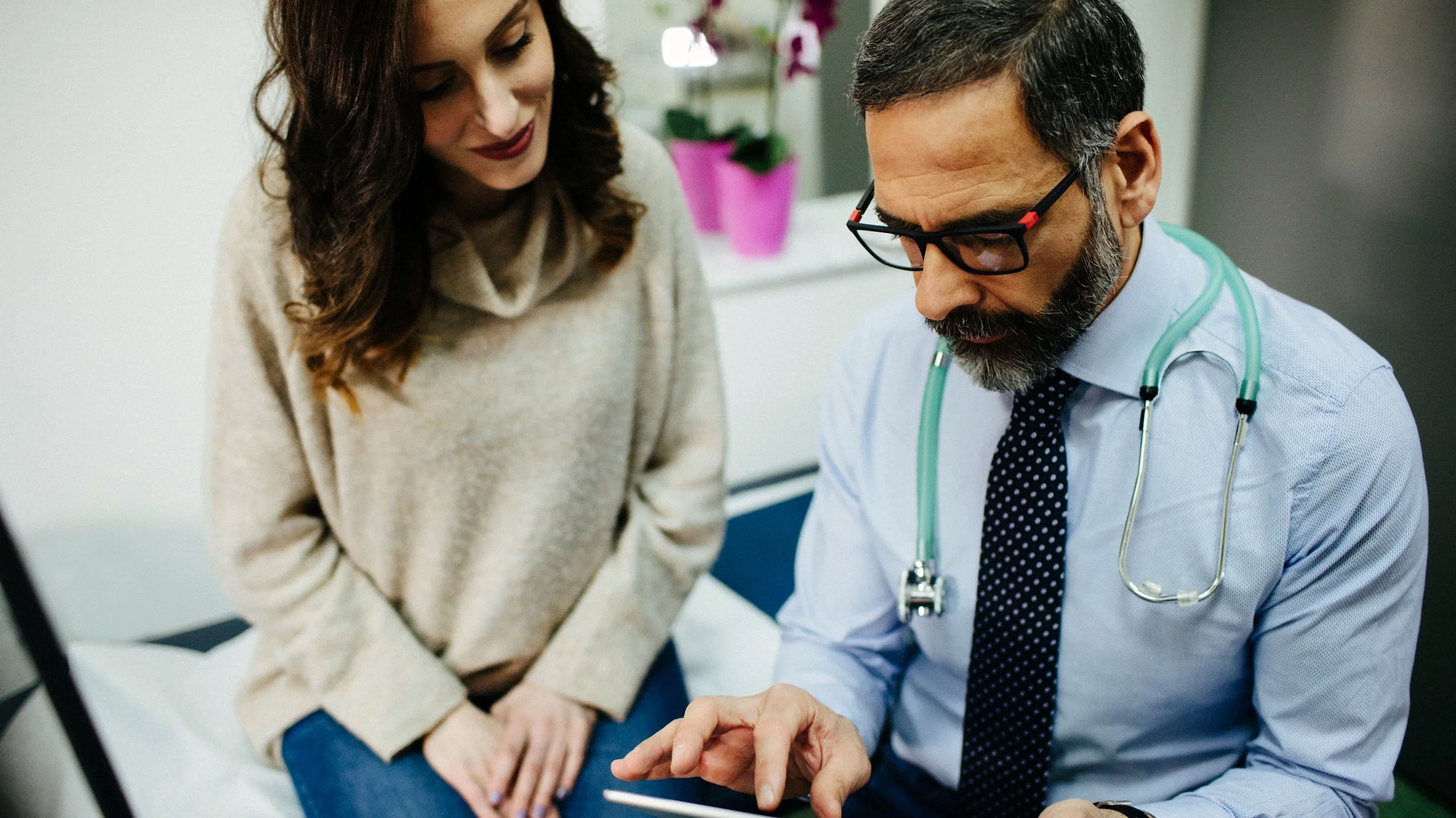 A doctor showing a tablet to a patient.