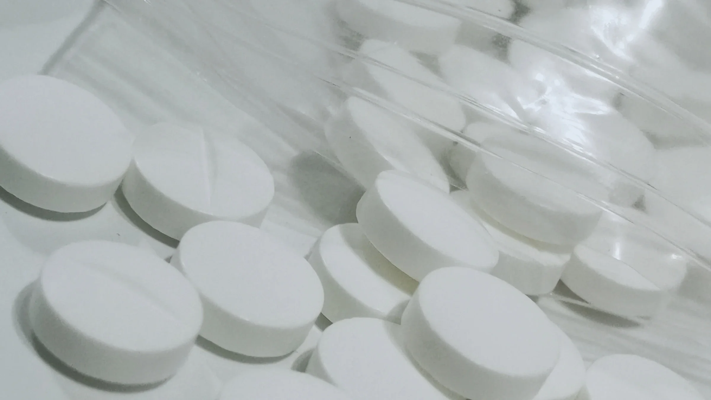 Metformin tablets spilling out of a plastic bag.