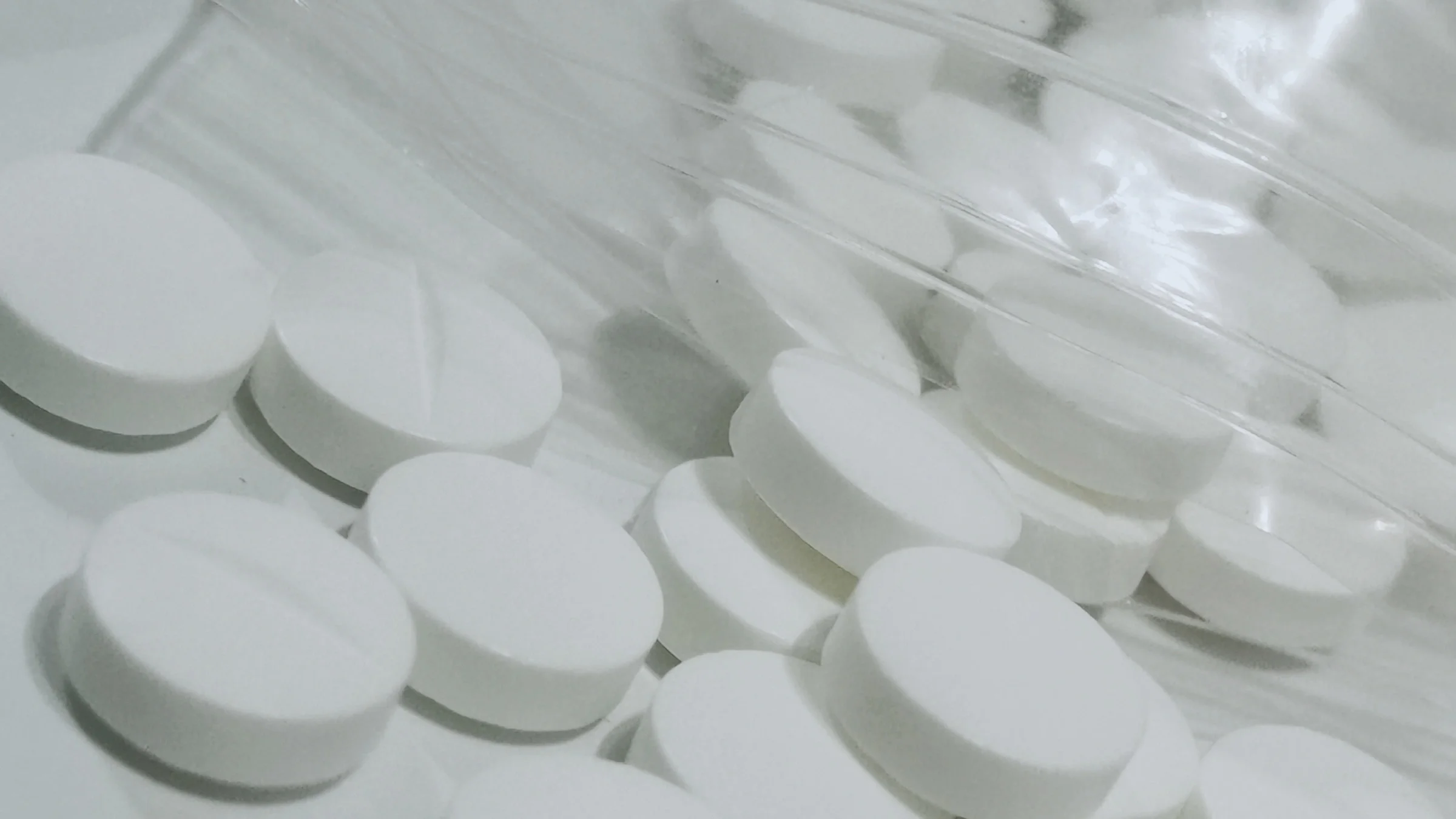 Metformin tablets spilling out of a plastic bag. 