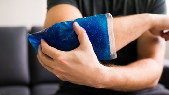 Environmental: closeup man holding ice pack on injured arm 1213744142