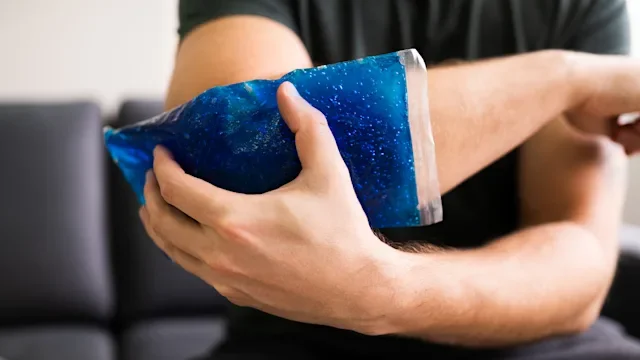 Environmental: closeup man holding ice pack on injured arm 1213744142