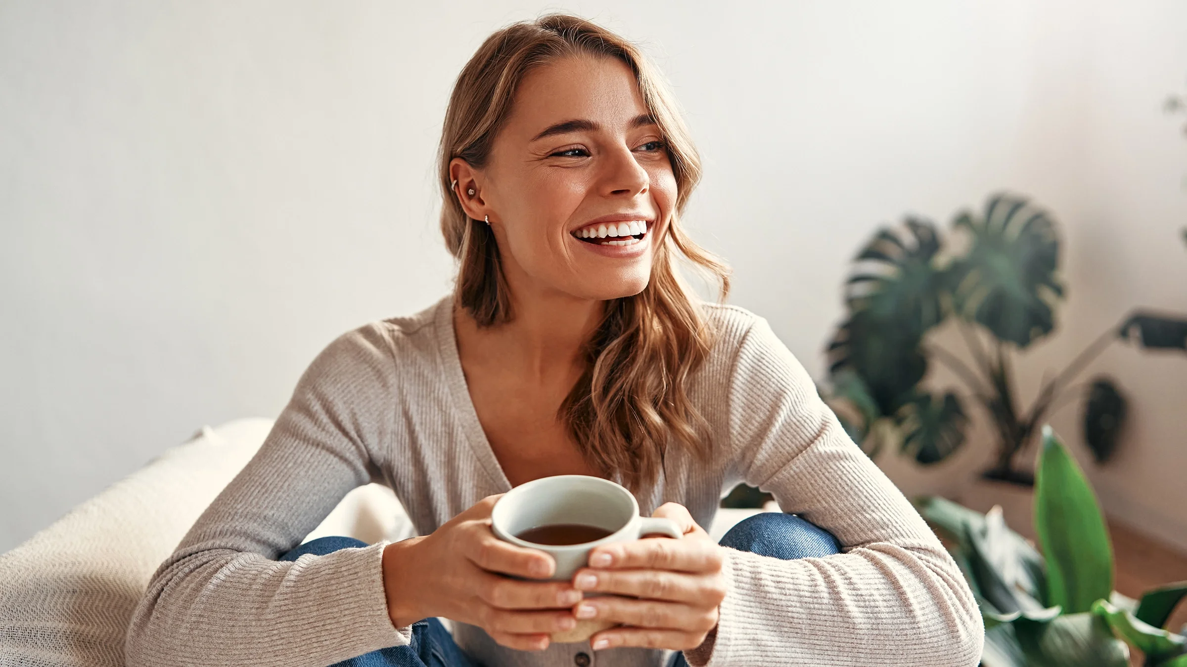 A woman is enjoying a cup of coffee at home.