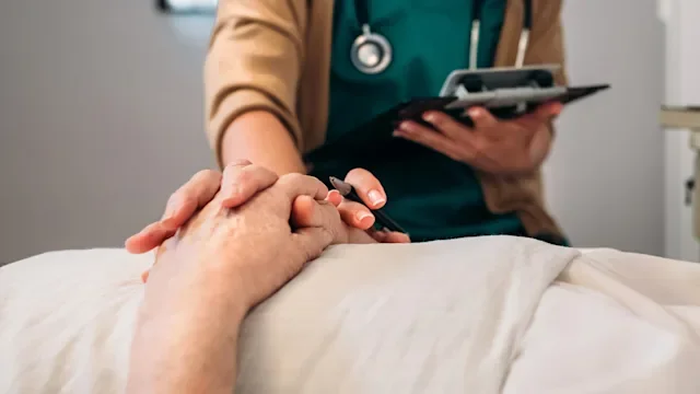 Providers: nurse holding patients hand-1219136359