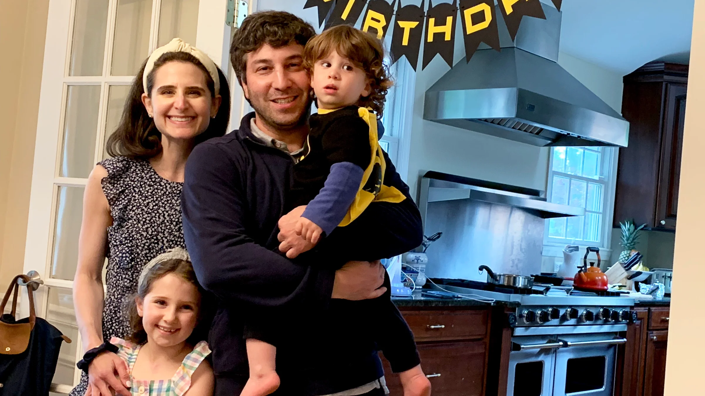Lerner with her husband and two children. There is a "Happy Birthday" banner in the doorway to their kitchen.