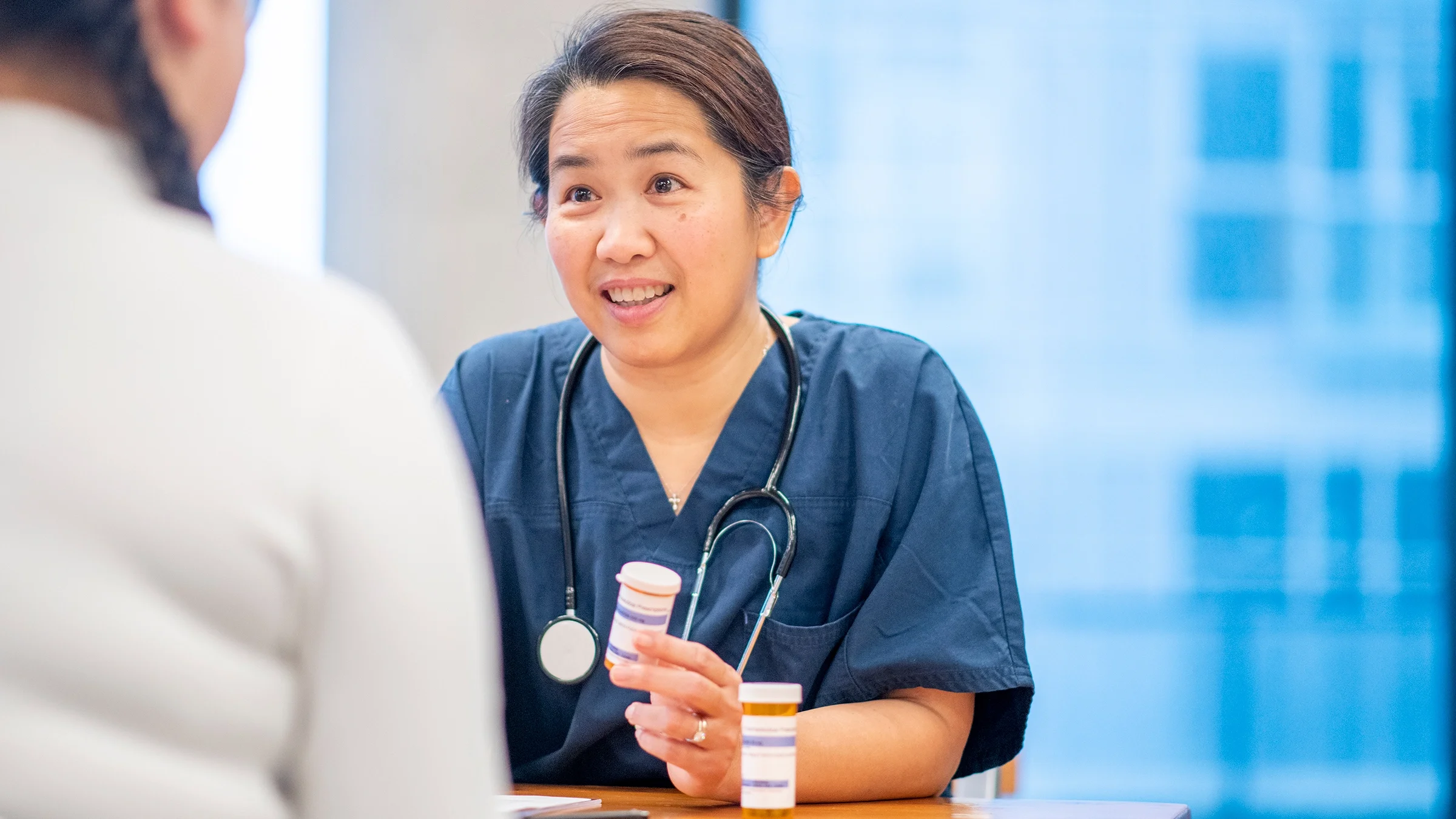 A healthcare professional is explaining medications to a patient.