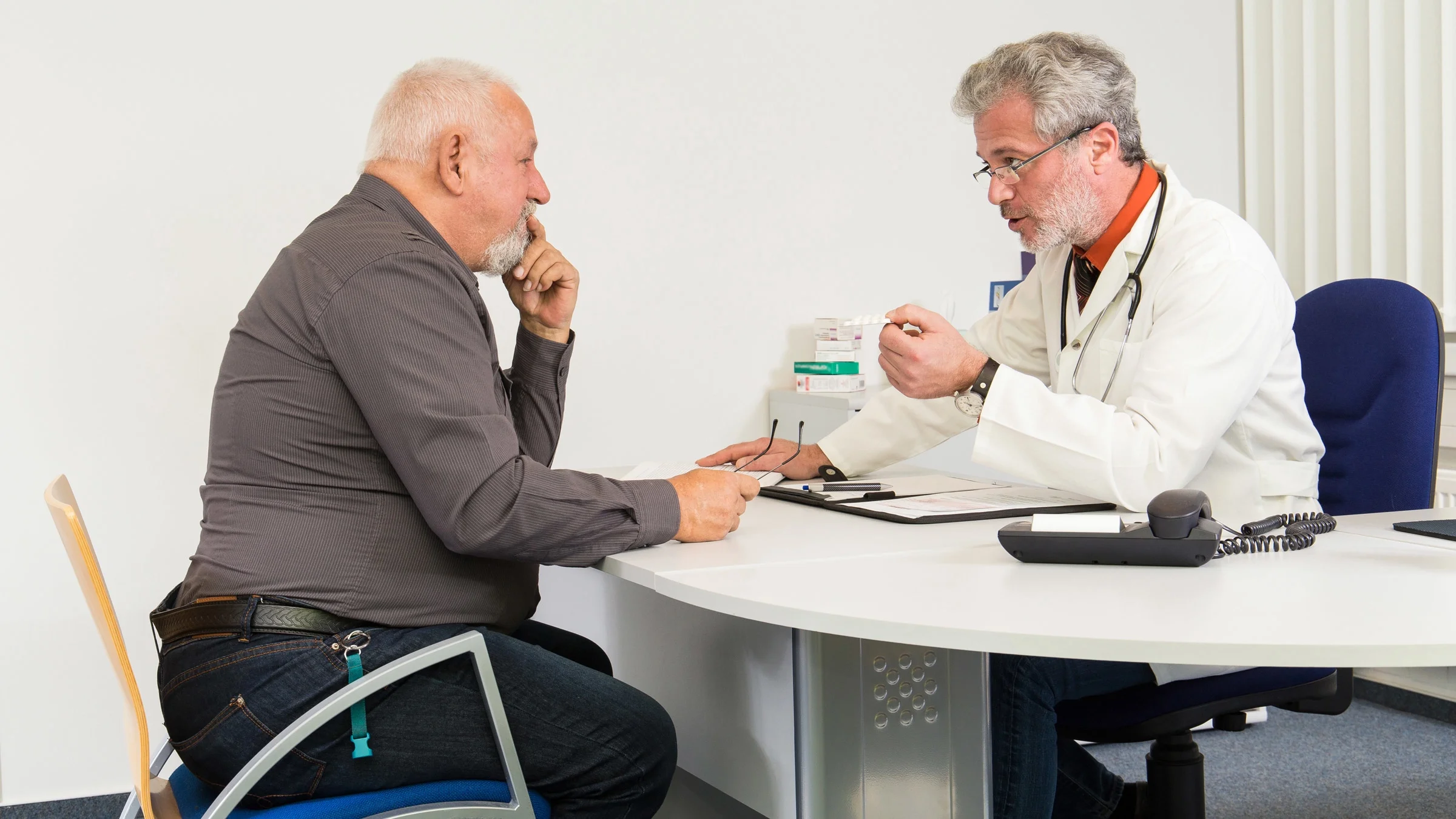 An overweight older adult talking to their doctor.