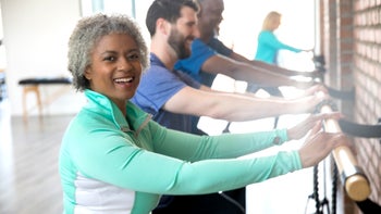 Movement-exercise: senior woman exercising at barre class 1143151128