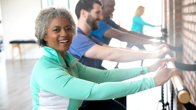 Movement-exercise: senior woman exercising at barre class 1143151128