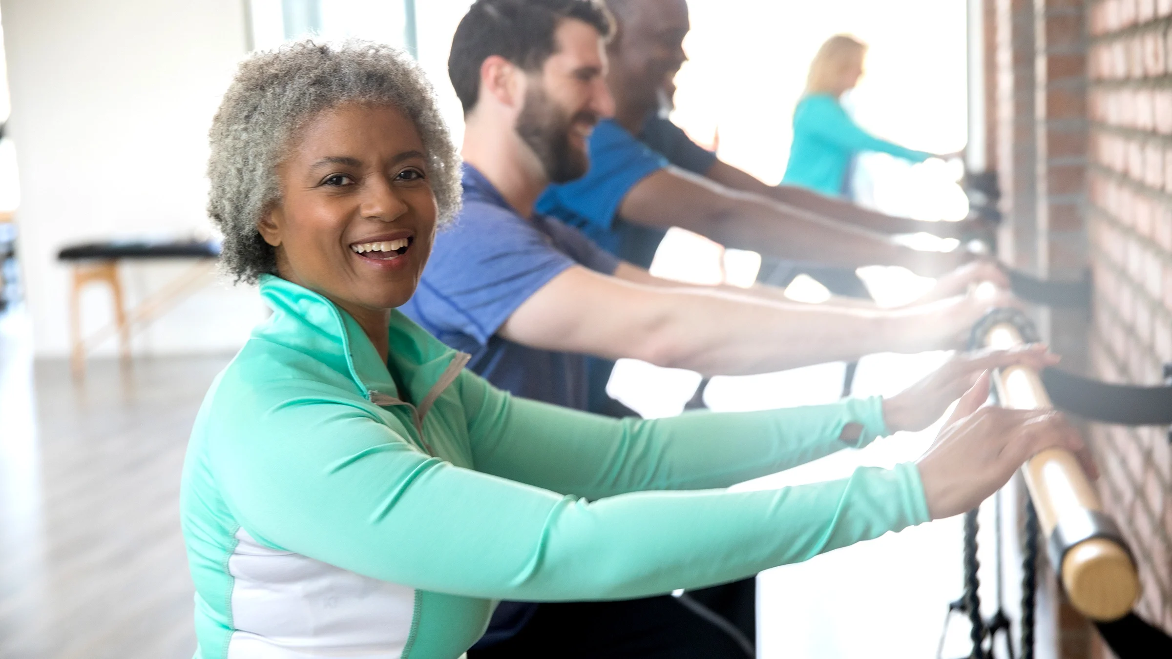 Senior woman exercising in barre class.